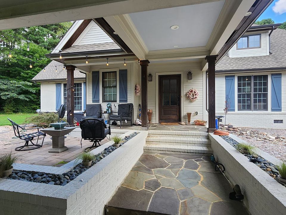 Enjoy a carport with a covered walkway leading to your home, complete with a welcoming front patio and spacious covered porch_perfect for relaxing outdoors in any weather.