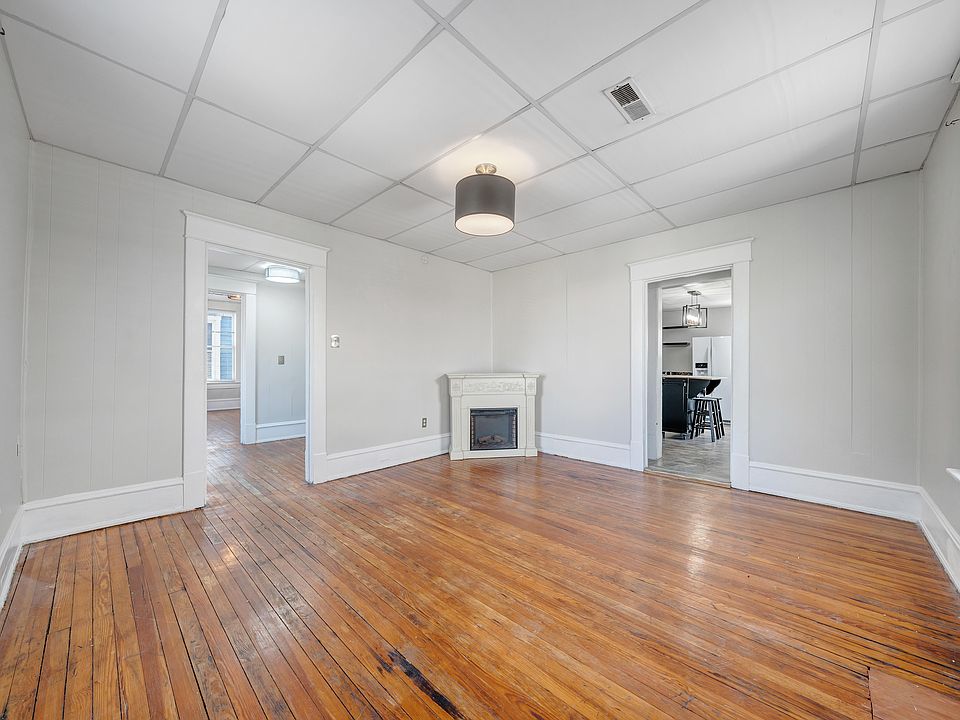 Spacious Living Room with Original Hardwood Floors, Designer Lighting and New Sherwin Williams Ammonite Gray Paint Throughout.