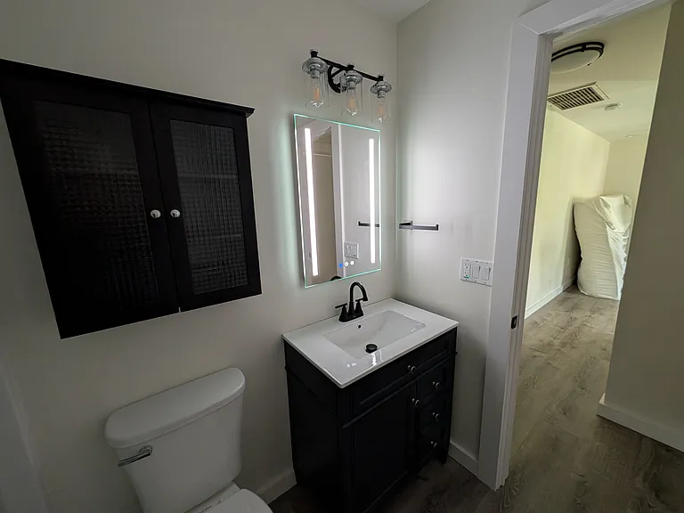 View from bathroom down hall to kitchen/living area