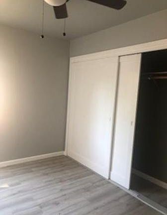 Second bedroom with same new laminate floor and fan light. shows closet size in each bedroom.