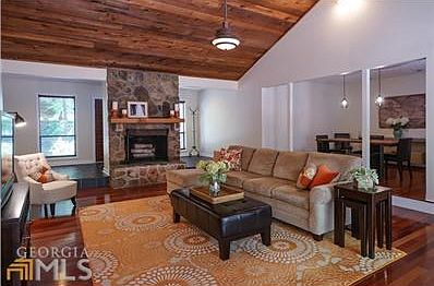 Another view of family room from foyer area with view of fireplace and windows.