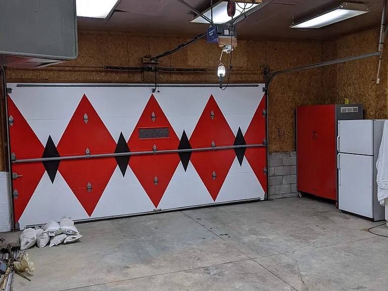 Extra large garage door. Space has many storage shelves.