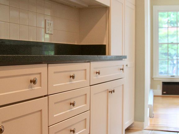 Renovated kitchen complete with recessed lighting, granite countertops, new stone work tiling, and high ceilings.