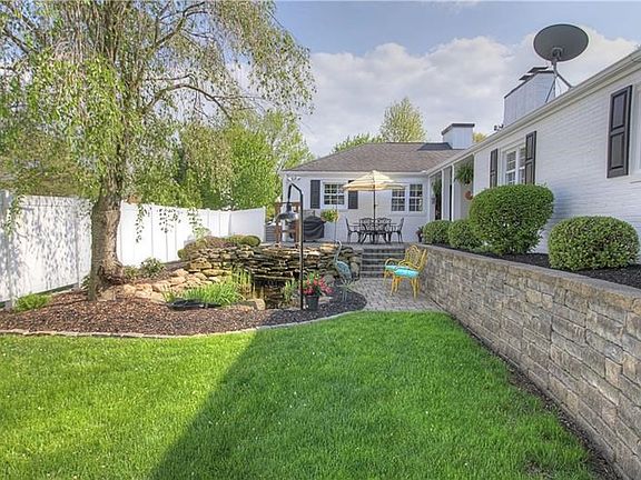 Enchanting private back yard is equally appealing. Featuring lounging areas by the pond, on the upper patio or under the covered