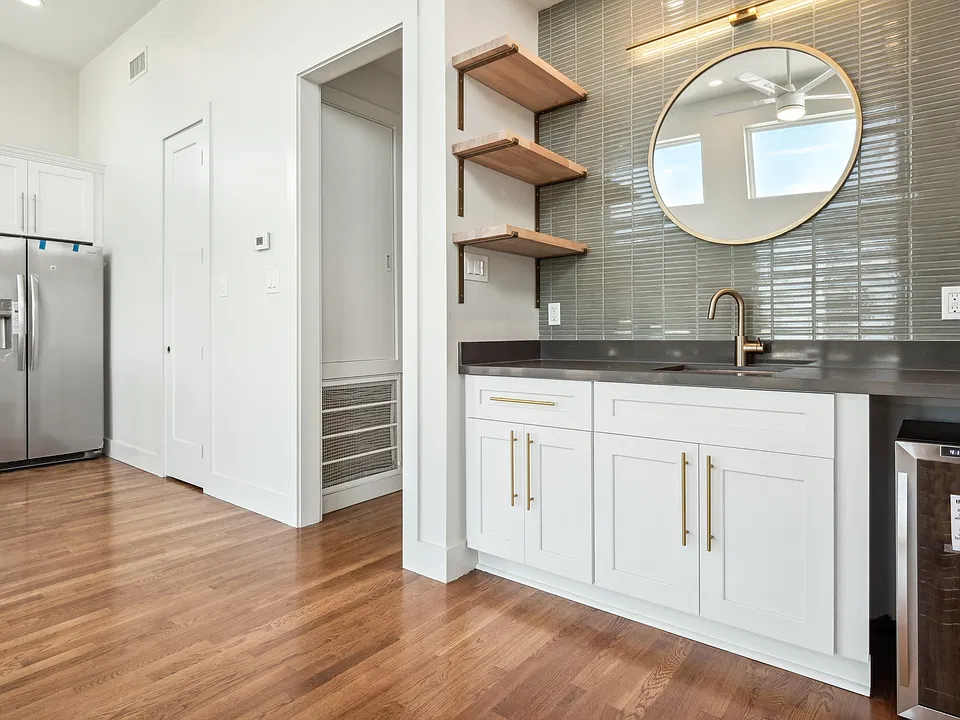 A custom built wet bar with sink and wine cooler. Shelving to display your bar collection!