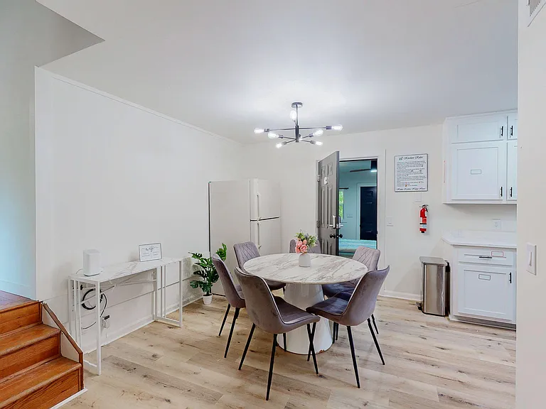 Open dining area with a round table, contemporary lighting, and easy access to the adjacent kitchen cabinetry.