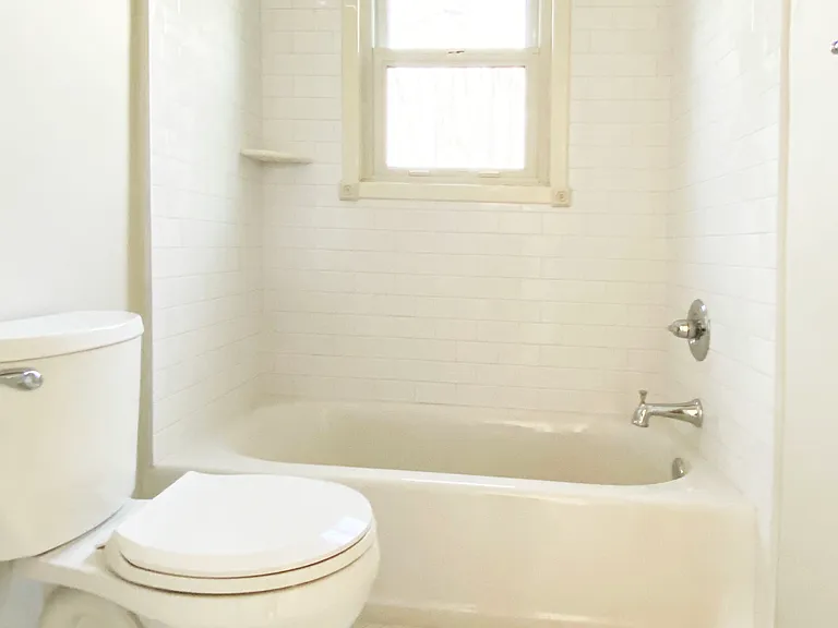 Bright white bathroom with tub shower and beautiful tiled walls and floor