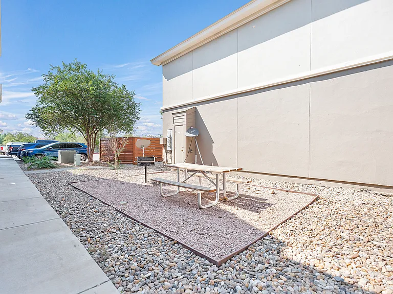 Outdoor patio at La Joya Apartments in Laredo, Texas, showcasing a picnic table set on a gravel surface