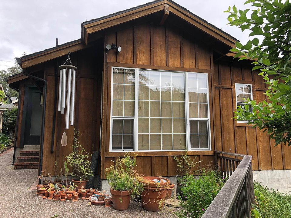 Front of cottage with large picture window overlooking creek.