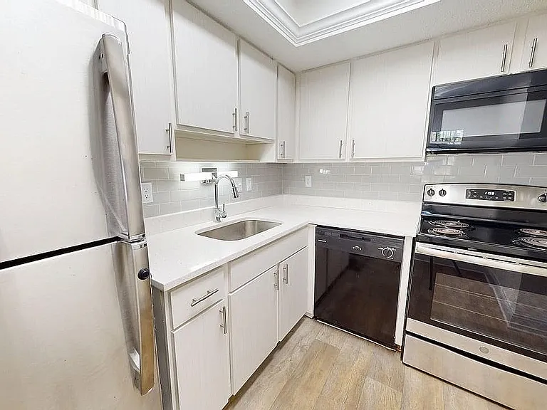 Modern kitchen with stainless steel appliances, sleek countertops, and elegant cabinetry.