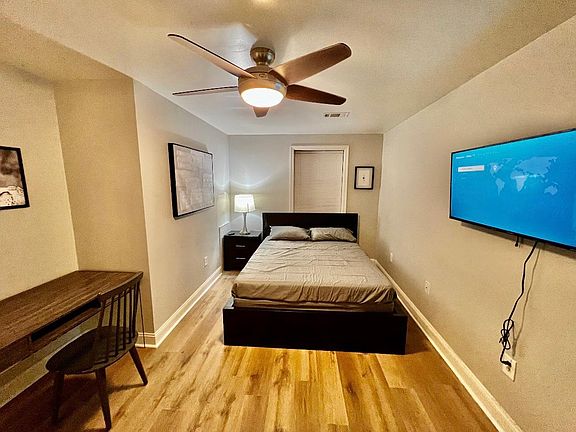 bedroom with queen bed , work desk, flat screen tv.
