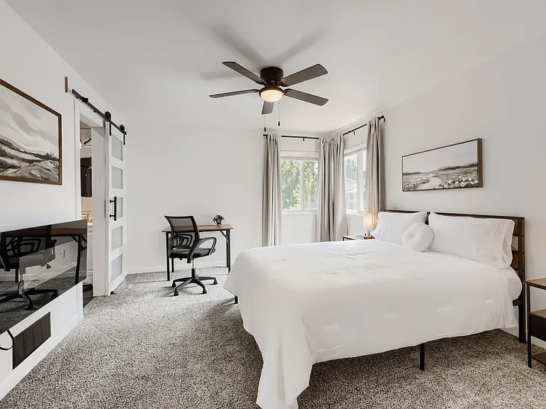 Spacious bedroom with a queen bed, work desk, nightstands w/USB, and blackout curtains. Bed linens and towels provided.