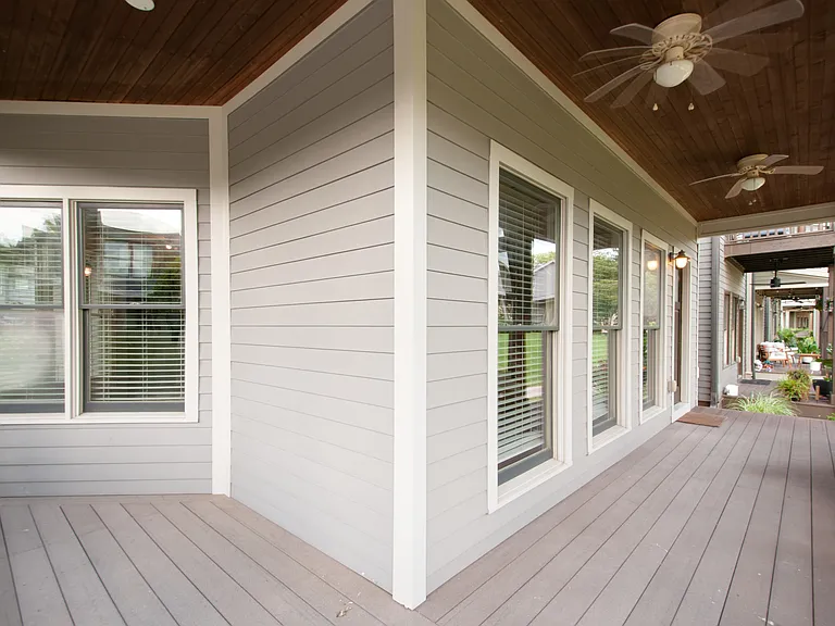 A welcoming wrap around porch with ceiling fans overlooking the common green space