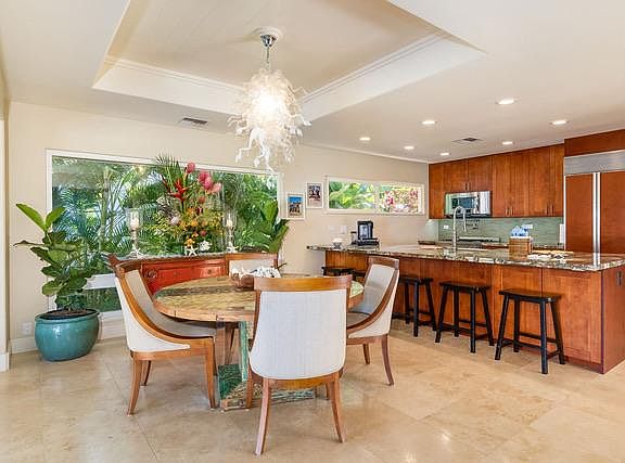 Kitchen with table with room for 6. Kitchen island with 5 counter seats and central sink, subzero fridge, gas stovetop and microwave.