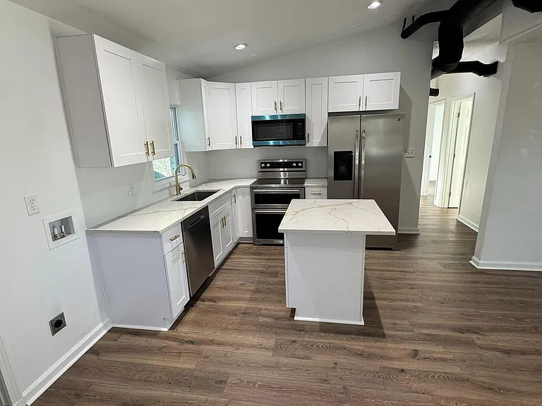 Updated kitchen with shaker cabinetry, stainless appliances, and a center island for prep space and casual dining.
