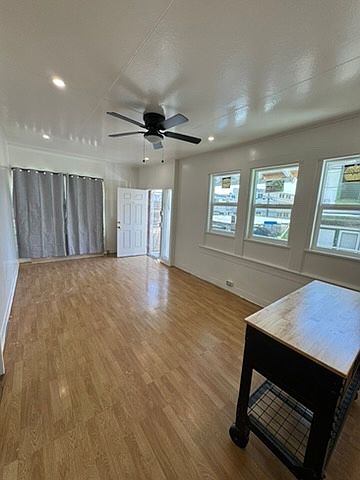 Entry into living area of open floor plan with combined kitchen and living area.