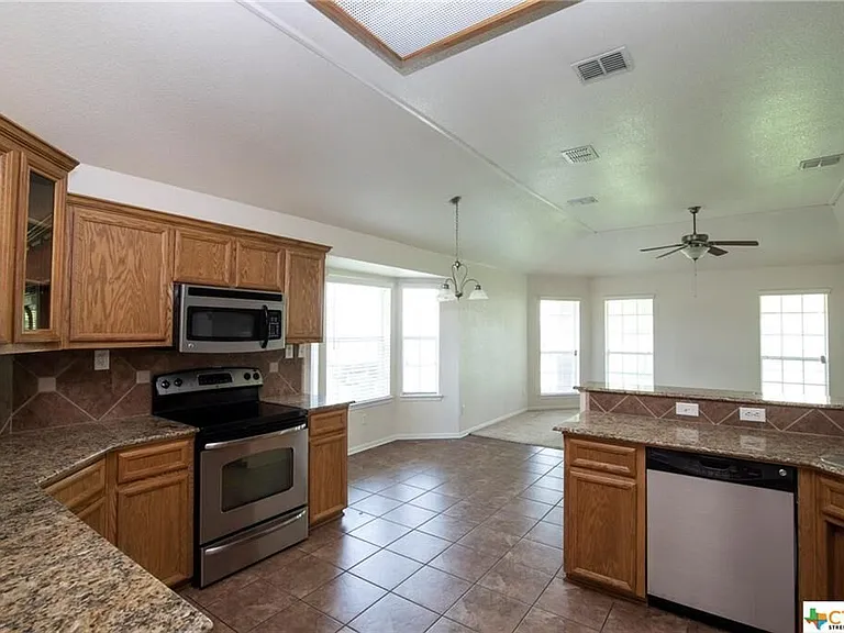Bright open kitchen with stainless steel appliances.