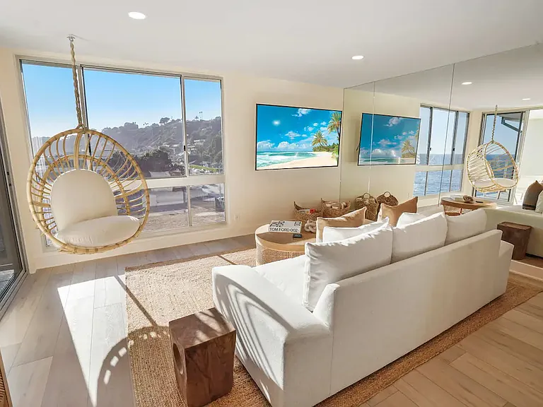 Sunlit living room offering panoramic ocean views and elegant, modern decor.