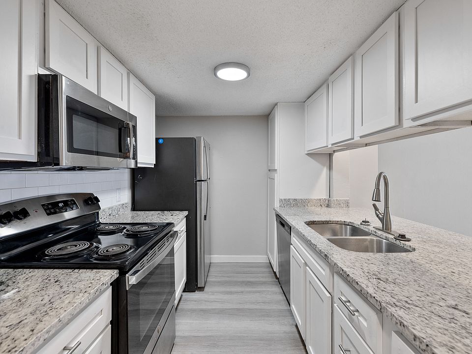A kitchen with granite countertops and stainless steel appliances.