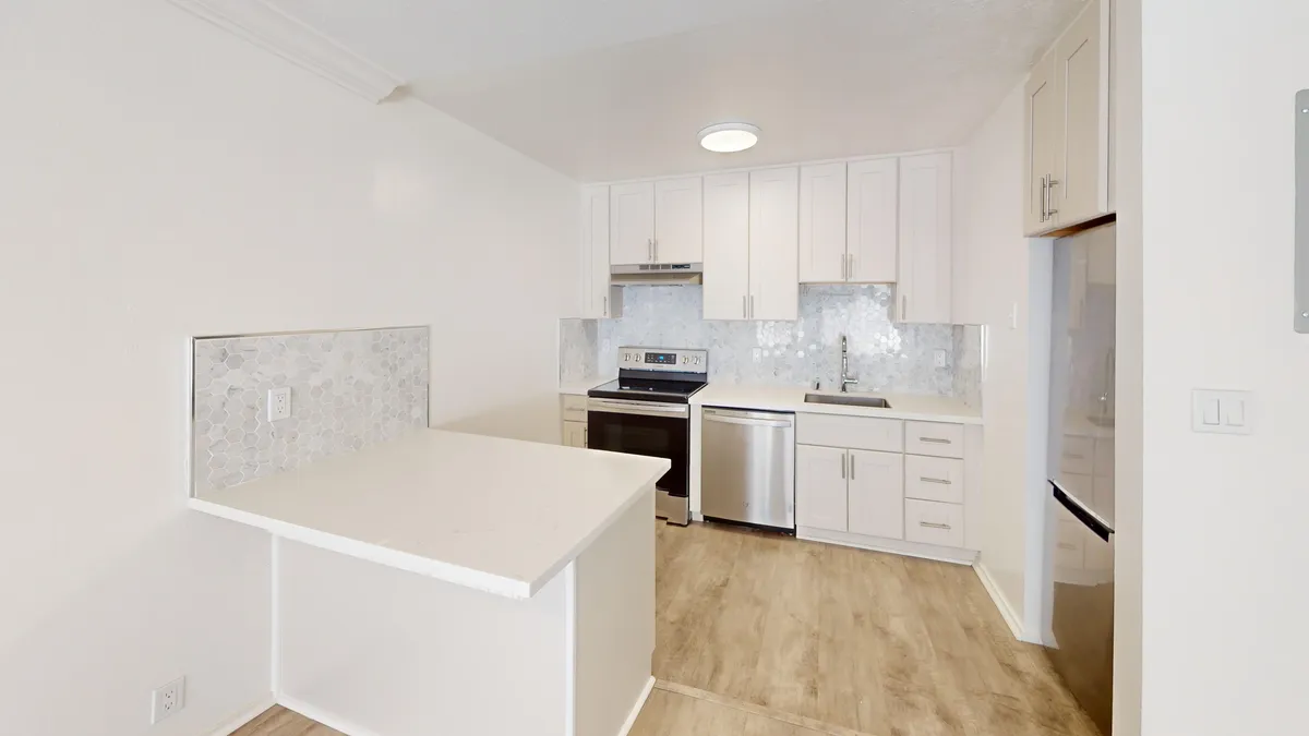 Kitchen with multiple cabinets, refrigerator, stove, range hood, and sink - 755 Green