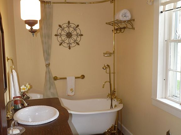 Restored bathroom with clawfoot tub and antique oak vanity