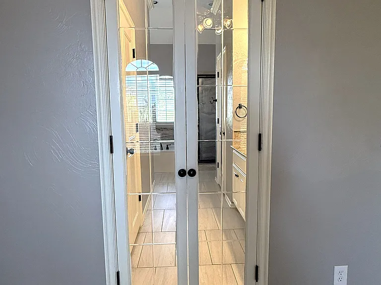 Glass doors leading into master bathroom.