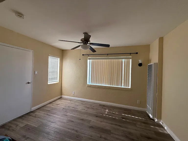 The living room has hardwood flooring, new window blinds, a ceiling fan, and wall heater.