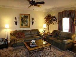 Formal living room features crown molding, marble tile floor, custom window treatments!