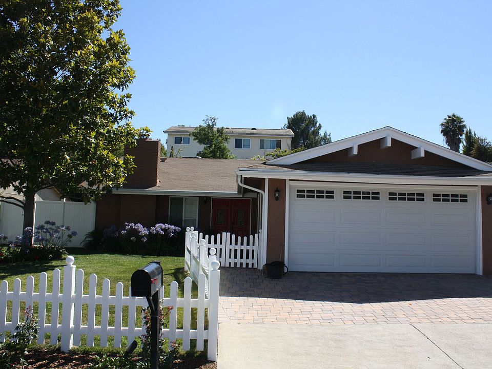 Fenced front yard and paver stone driveway