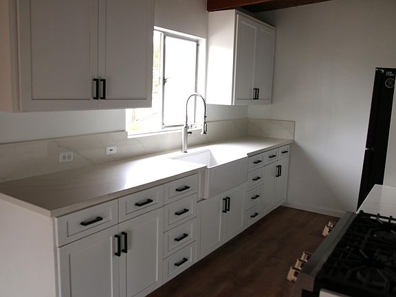 Kitchen with new farmhouse sink, new cabinets and new gas range.
