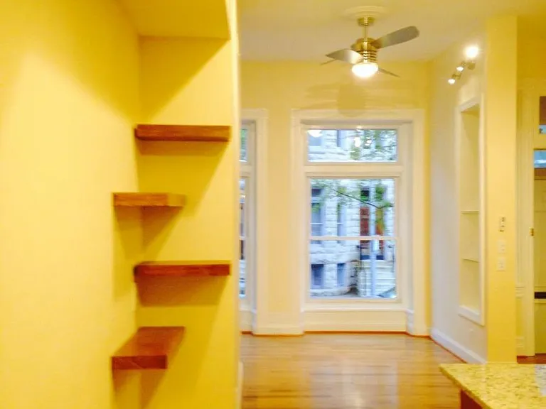 Floating shelves in kitchen facing living room