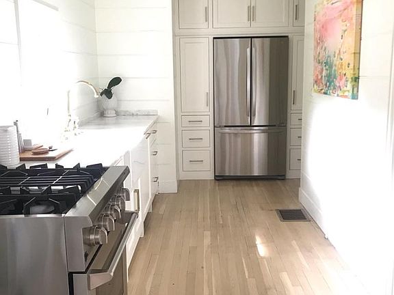 Newly renovated kitchen with marble countertops, custom cabinets, and stainless appliances.