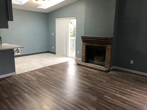 Open concept from kitchen with space for counter height chairs, that opens ups to the dining/living room with a wood burining fireplace. Has opening to the back patio to a fully fenced backyard. There are skylights in the dining area too!