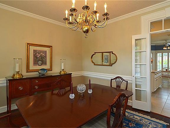 Crown moulding and chair rail accent hardwood flooring in dining room.