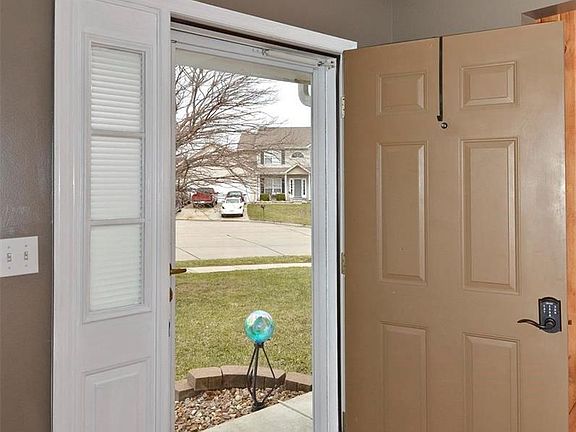 Light and bright entryway has tile flooring and storm door.