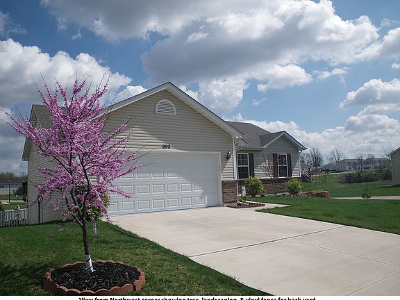 From Northwest corner showing tree, landscaping, & vinyl fence for back yard.
