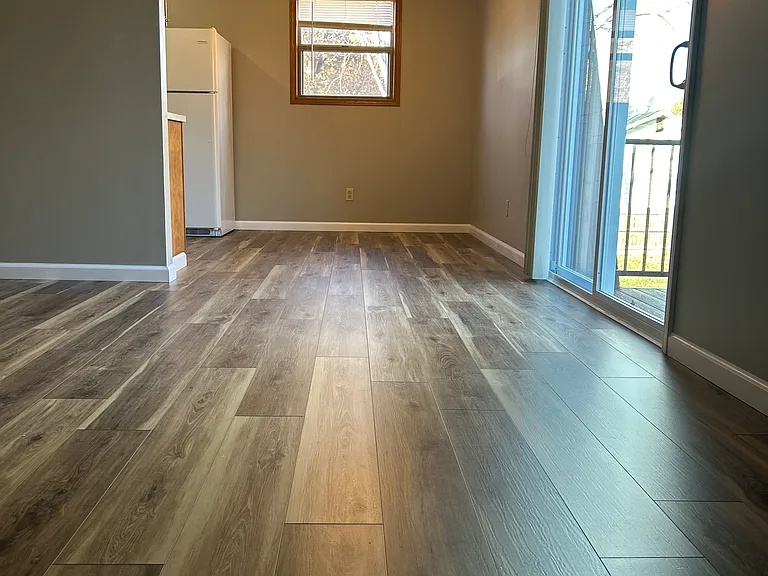 Open living room and dinning area with patio door access to balcony