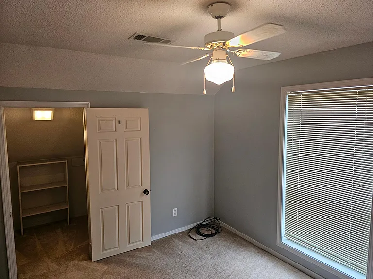 Second bedroom with ceiling fan, closet, & full bath attached.