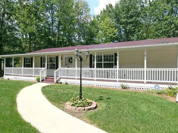 Closer picture of the wrap around porch and curving sidewalk leading to the front door. The driveway and sidewalk were recently added. This 1680 sq ft home boasts 3 bedrooms and 2 bathrooms plus a separate den or office. 