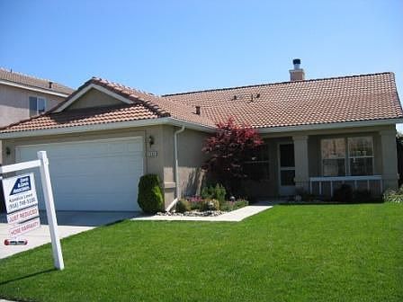 Front view of this charming three-bedroom home showcases well-cared for yard. 
