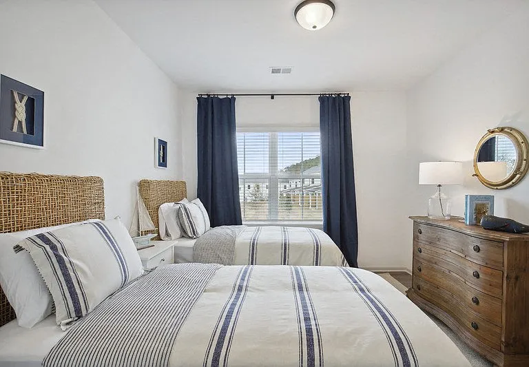 Relaxing shared bedroom with twin beds and a nautical-themed nightstand detail.