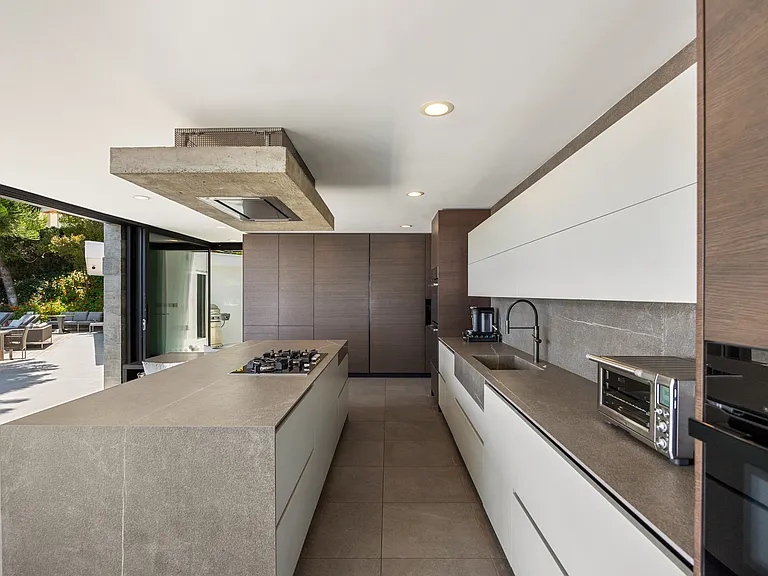 Sleek countertops and modern cabinetry offer ample storage and workspace, perfect for gourmet cooking.