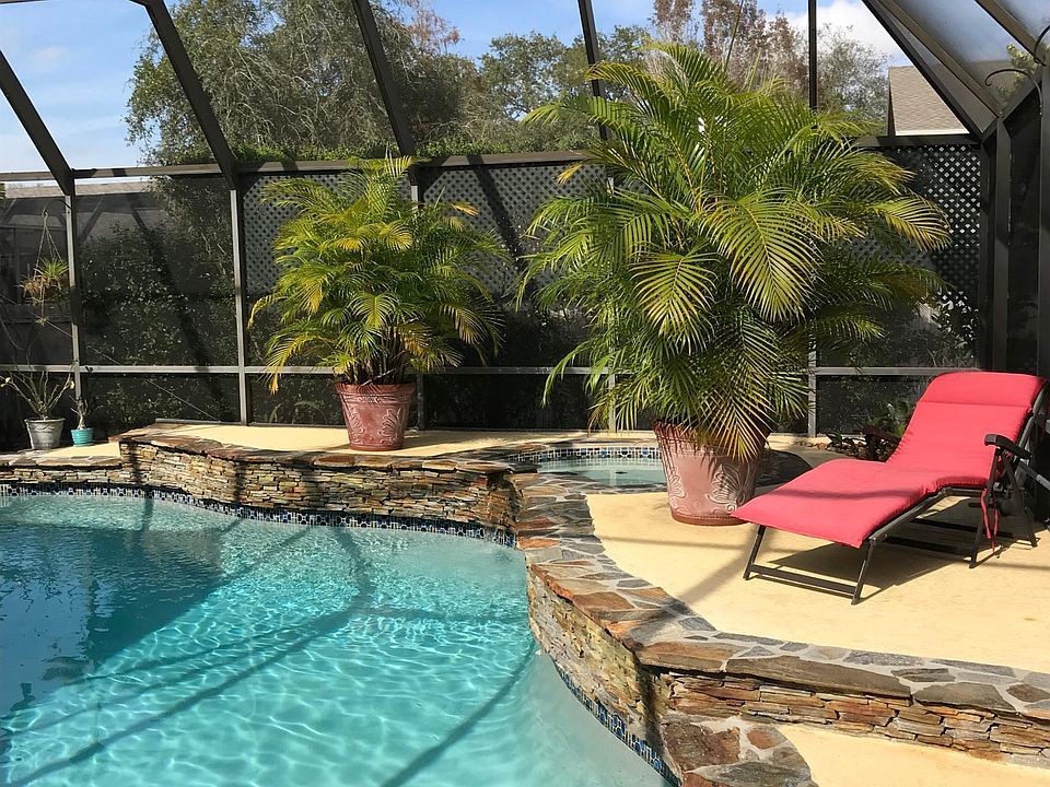 Screened in pool and patio with mature foliage and partially shaded.