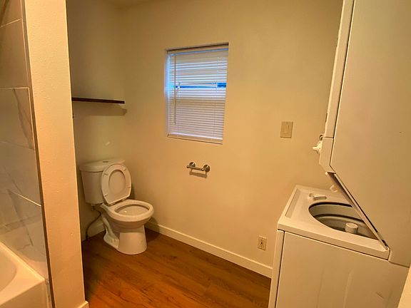 Convenient full bathroom with shower, washer/dryer, and built in shelving for easy organization and every day comfort