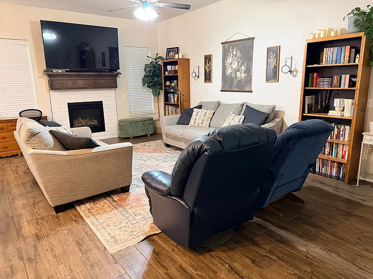 Current living room setup. Fireplace, wood tile floors, great lighting.
