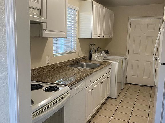 Galley Kitchen with a dishwasher, electric oven and refrigerator.