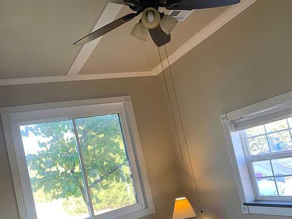 living room with crown molding, ceiling fan