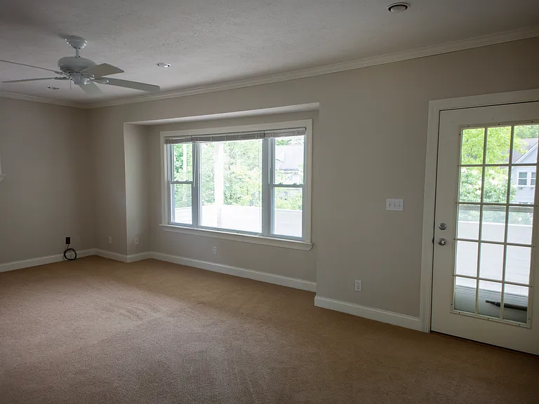 Large windows and direct balcony access create a bright indoor-outdoor living experience.
