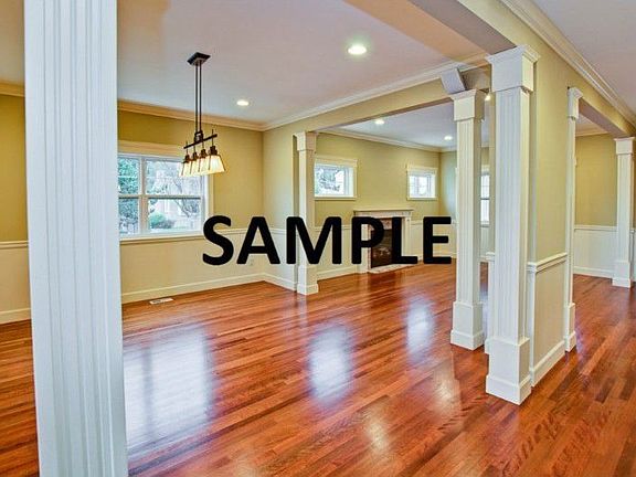 Example of the open plan entry, formal living and dining spaces. Note the builder's use of ornate millwork, dual tone painted walls and a double Swedish finish on the flooring.