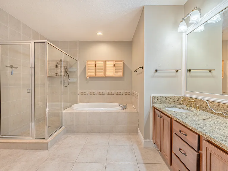 The primary bathroom has a soaking tub, a separate standing shower, and a double sink vanity.